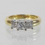 An 18 carat gold diamond ring, set with three princess cut stones, approximately 1.