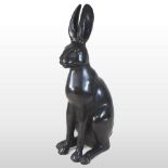 A life size bronze sculpture of a hare, naturalistically modelled in a seated pose,