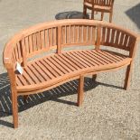 A teak curved garden bench,