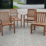 A collection of four teak garden armchairs