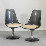 A set of four modern smoked plastic swivel dining chairs