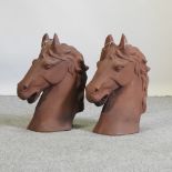 A pair of rusted metal horse head gatepost finials,