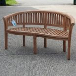 A teak curved garden bench,