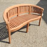 A teak curved garden bench,