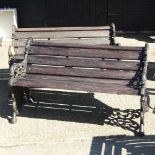 A pair of black painted cast iron and wooden garden benches,
