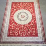 An Aubusson style carpet, on a red ground,