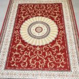 An Aubusson style carpet, on a red ground,