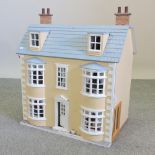 A painted wooden doll's house, 65cm wide,