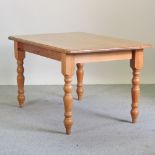 A pine kitchen table, on turned legs,