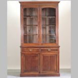 A Victorian oak cabinet bookcase, with a glazed upper section,