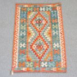 A woollen kelim rug, with all over geometric design, on a green ground,