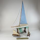 A mid 20th century wooden pond yacht on stand, 89cm high overall, together with two others smaller,