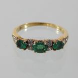 An 18 carat gold diamond and emerald half hoop eternity ring,