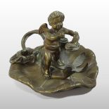 A Victorian brass articulated figural chamberstick, in the form of a winged cherub, on a lily pad,