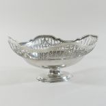 An early 20th century silver oval dish, of scalloped pedestal shape, with a pierced border,