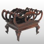 An ornate carved rosewood four division canterbury, with scrolled decoration,