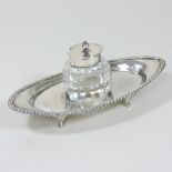 An early 20th century silver desk stand, of elliptical shape, with a gadrooned border,