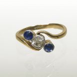 An 18 carat gold, sapphire and diamond three stone ring, of crossover design,