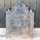 A large cast iron fire back, of arched shape, relief decorated with figures,