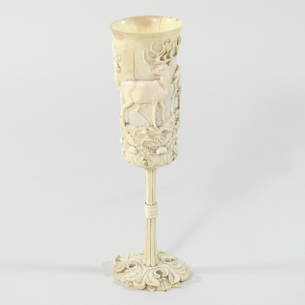 A 19th century German carved and turned ivory hunting cup, of slender form,