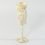 A 19th century German carved and turned ivory hunting cup, of slender form,