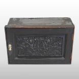 An 18th century carved oak spice cabinet, fitted with an arrangement of twelve short drawers,