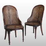 A pair of early 20th century cane bergere chairs, on turned legs, with loose cushions,