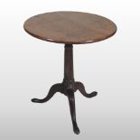 A George III oak occasional table, with a circular top, on a tripod base,