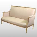 A French style carved and gilt painted cream upholstered sofa, on turned legs,