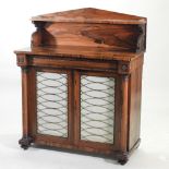 A Regency rosewood chiffonier, with a shaped gallery back, enclosed by a pair of brass grille doors,
