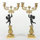A pair of 19th century French Empire bronze and gilt metal figural candelabra, with cherub supports,