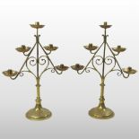 A pair of brass table candlesticks, each of angular scrolled shape, with five tiered sconces,