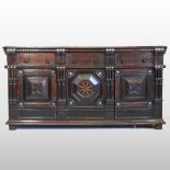 A 19th century continental oak sideboard, with geometric carved panels and bone roundels,