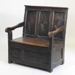 A 18th century and later carved oak box settle, with a panelled back and rising seat, 92cm,