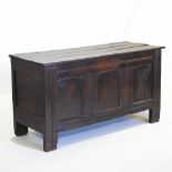 An 18th century oak coffer, with a hinged lid and panelled front,