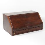 A George III mahogany miniature bureau, with a fitted interior, enclosed by a hinged sloping fall,