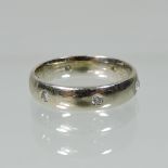 An 18 carat gold and diamond wedding ring, set with six stones,