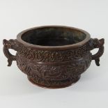 A Chinese bronze censer, of twin handled circular shape, with relief decoration,