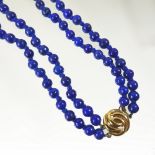 A lapis lazuli double strand bead necklace, with a 9 carat gold clasp,