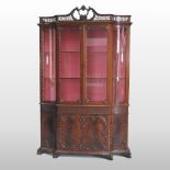 An Edwardian carved mahogany display cabinet, of serpentine form,