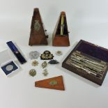 A collection of items, to include two metronomes, a compass set,