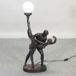 A bronzed figural table lamp, in the form of a couple dancing, with an opaque glass globe shade,