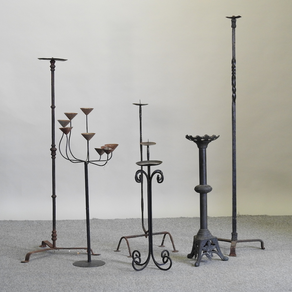 A collection of six various iron floor standing candlesticks,