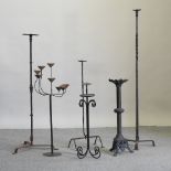 A collection of six various iron floor standing candlesticks,