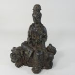 A Chinese bronze figure group of Guanyin, seated on a dog of fo,