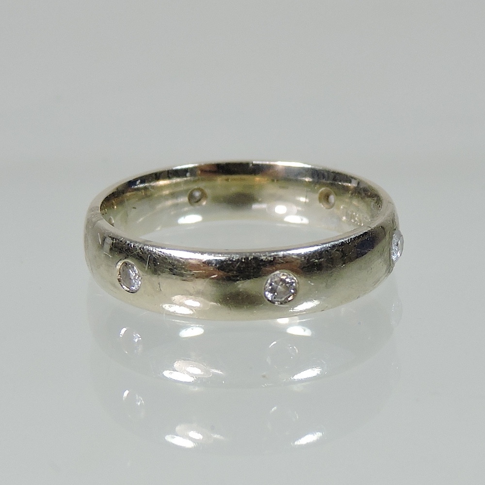 An 18 carat gold and diamond wedding ring,
