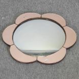 An Art Deco convex wall mirror, of flowerhead design, with an amber glass surround,