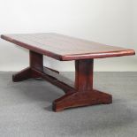 A hardwood refectory dining table, on trestle ends,