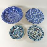 A Persian Iznik tin glazed dish, together with three others,