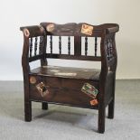 A stained pine settle, decorated with stickers,